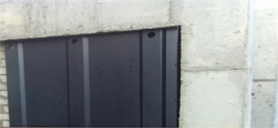 Installation of waved steel panels to concrete frame