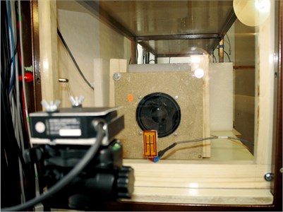 a) The experimental setup and b) the laser triangulation head used  to emulate the laser microphone and the actuating element