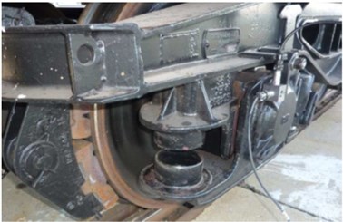 a) Goods wagon bogie with removed springs on one side and  b) passenger car running gear with secondary suspension damper disconnected