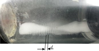 Photos of levitating microparticles on the vibrating cylinder wall nodal sections  at different excitation frequencies: a) 2.44 kHz, b) 14.2 kHz