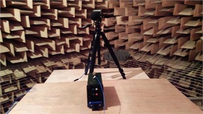 Device during vibroacoustic test in anechoic chamber:  a) rear view of the device, b) side view of the device