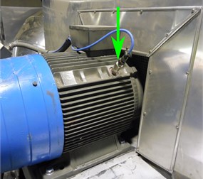 Photo of a monitored centrifugal over-hung fan with a sensor placement marked by a green arrow