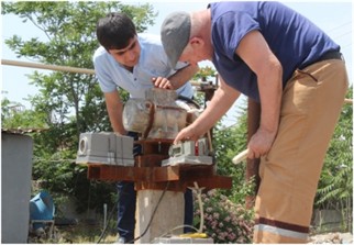 The SM-3 sensors and a vibrator on railroad roadbed in three-axis coordinate system x,y,z.  The photograph, taken by the second author on May 19, 2022, depicts the process  of installing seismometric sensors on a model (prepared by the second author) designed  to record the process of vibrations in the ground surface