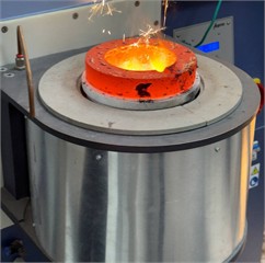 Melting process in an induction crucible furnace. Photo taken by the authors in the laboratory of the Almalyk Branch of NUST MISIS, 2025