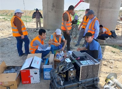 Bridge’s photo and photo of the monitoring studies in progress: a) photo of the bridge, b) photo of monitoring studies in progress. The photos were taken by S. Takhirov on May 30, 2025