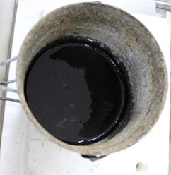 Immersion of specimens into the molten salt bath. Photo by the authors  in the laboratory of the Almalyk Branch of NUST MISIS 2026